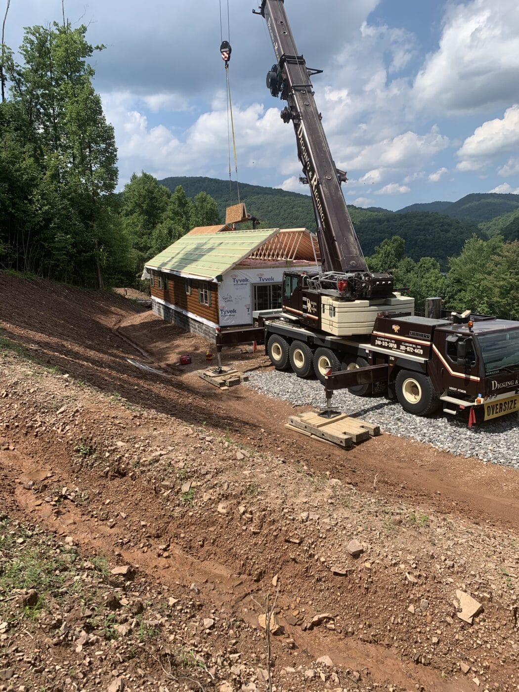 a crane setting the roof on a prefab login cabin in parson west virginia