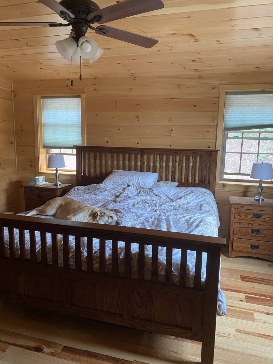 a nice sized master bedroom inside of a gorgeous wooden prefab log cabin
