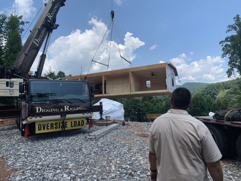 postioning the modular pieces of a prefab cabin in the prepared site in parson west virginia