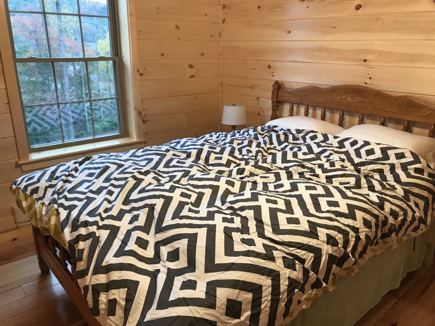 second bedroom with decorative wooden bed inside of a prefab log cabin