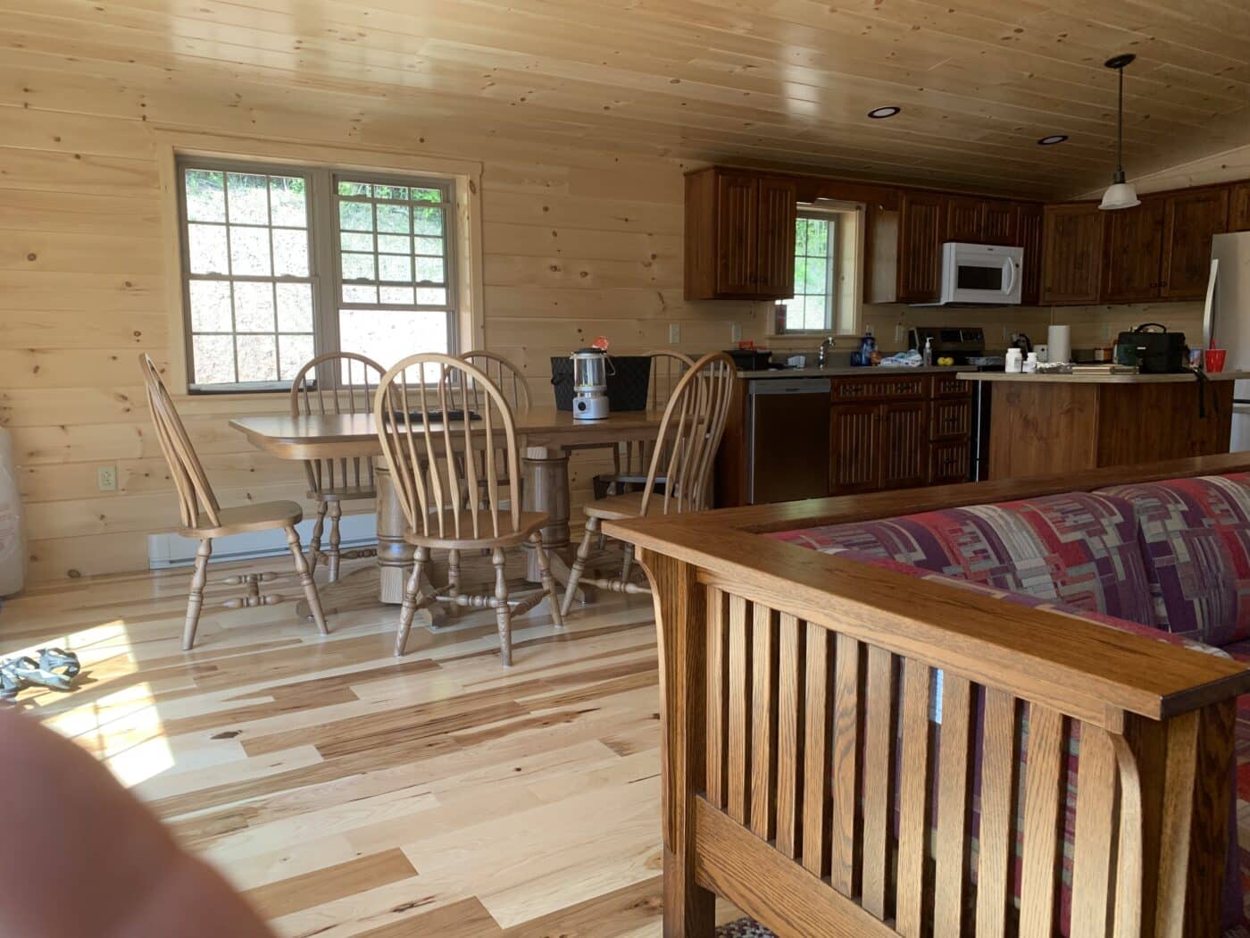 the open dining and kitchen area inside of a completed prefab log cabin