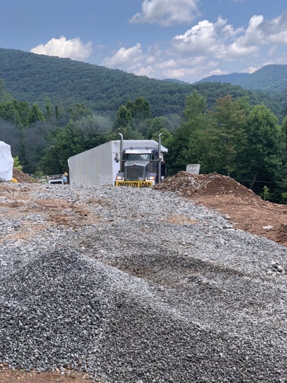 tractor trailer bringing prefab log cabin to parson west virgina prepared site