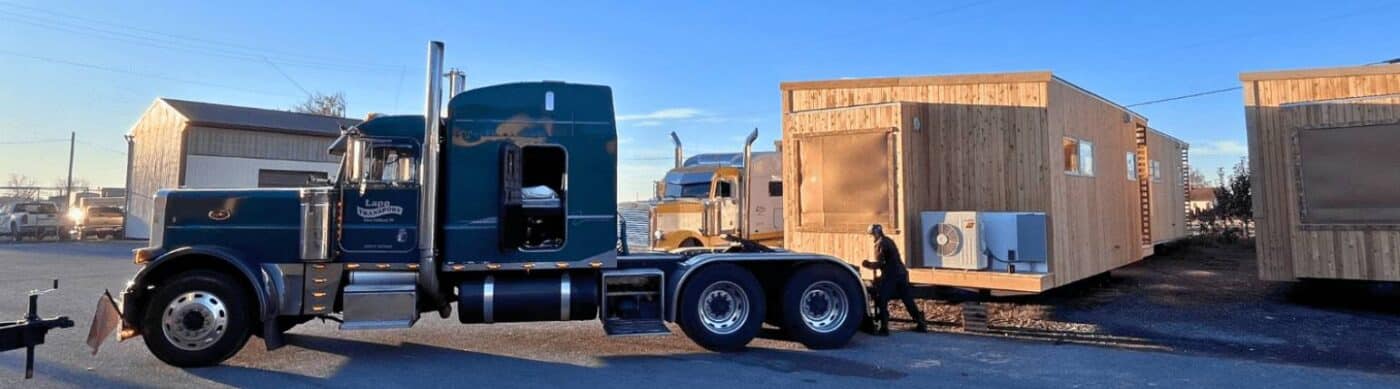 Park Model on the back of truck being placed on site