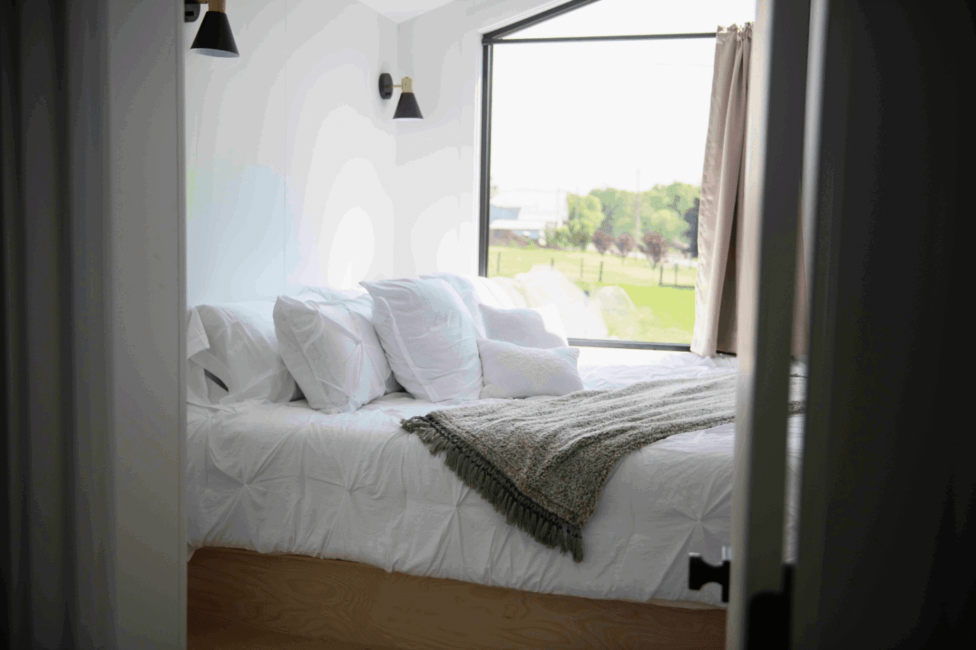 Bedroom with King sized bed in a frame tiny home built and designed by Zook Cabins in New Holland Pa