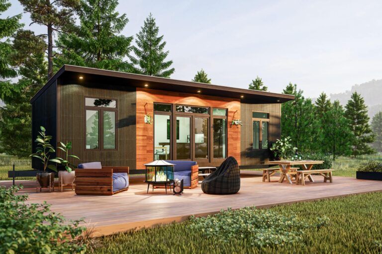 Modern tiny home with a sleek black and wood exterior, spacious outdoor deck featuring seating, a fire pit, and surrounded by lush greenery and trees.