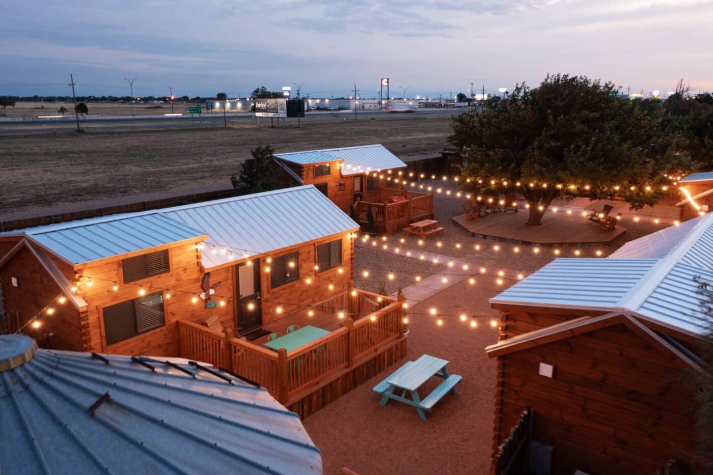 Overhead view of tiny home community featuring pinecrest park model tiny home, string lights, and picnic benches