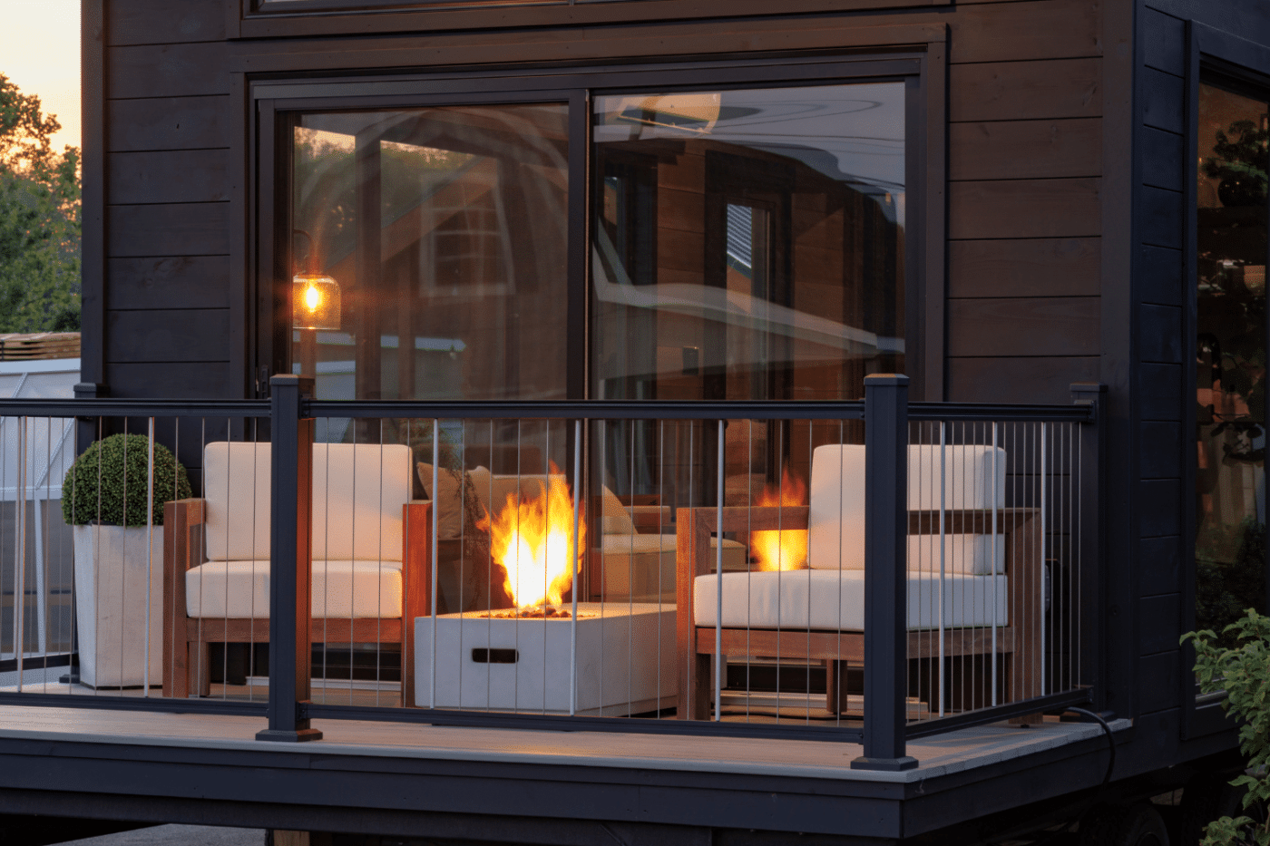 close up of fire pit and chairs on porch of park model tiny home