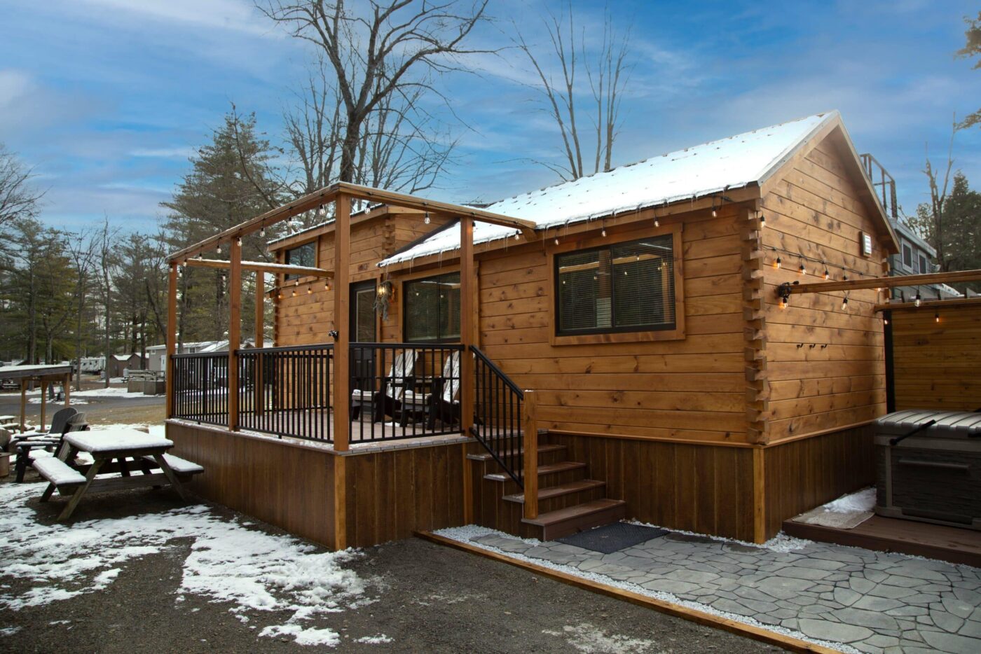 log cabin style park model tiny home on permanent foundation with back porch