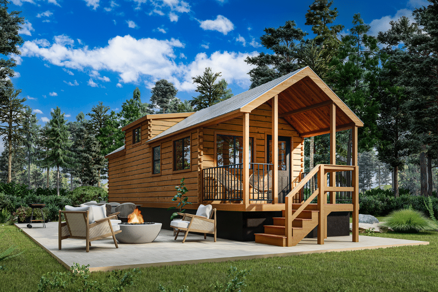 wooden park model home on concrete pad with front patio surrounded by trees