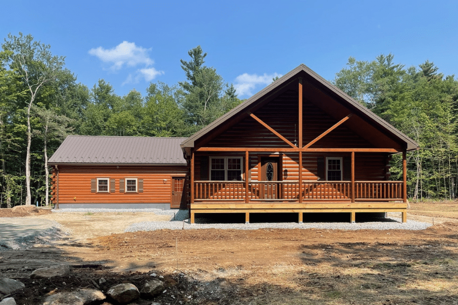 Settler log cabin with covered front porch in woods