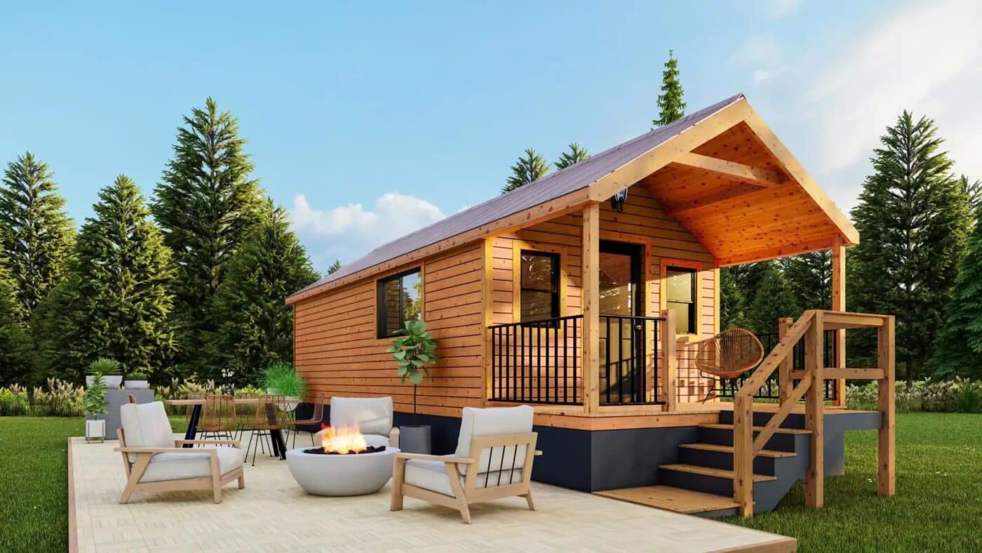 Rustic-style park model tiny home with a covered porch and outdoor seating area.