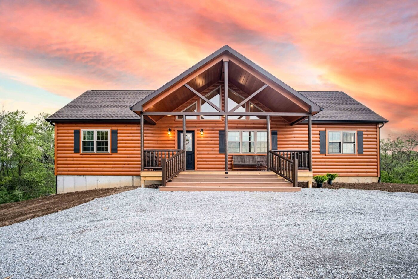 Alpine log cabin in Pennsylvania with covered porch at sunset.
