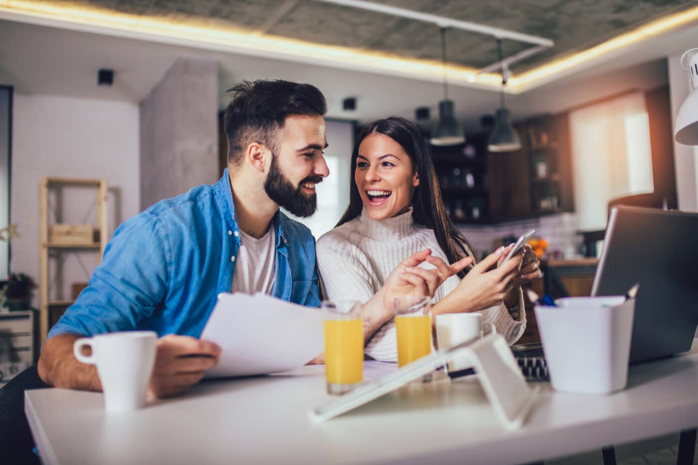 Happy couple doing business together working at home on the lapt